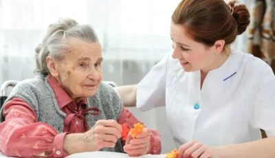 Caregiver supporting an elderly person in an activity, illustrating the compassionate 24-hour developmental disability services provided by A Different World Home Services LLC.